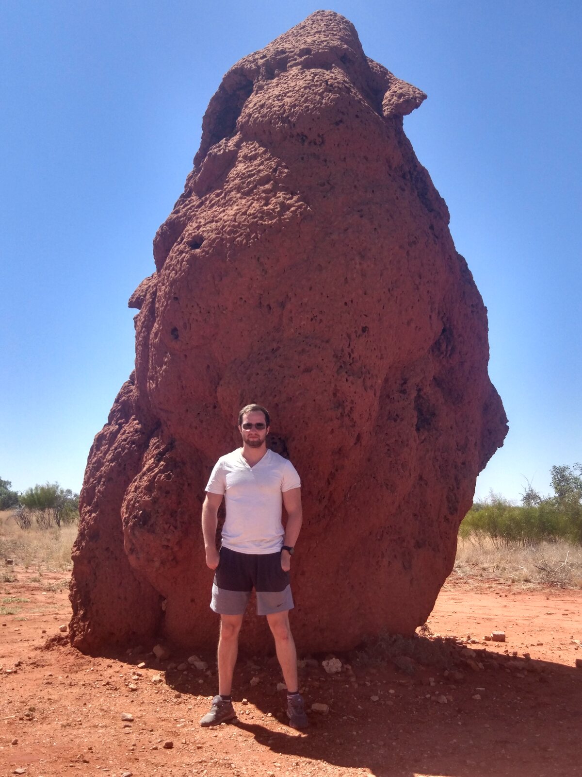 Beside a giant termite mound in the Australian outback