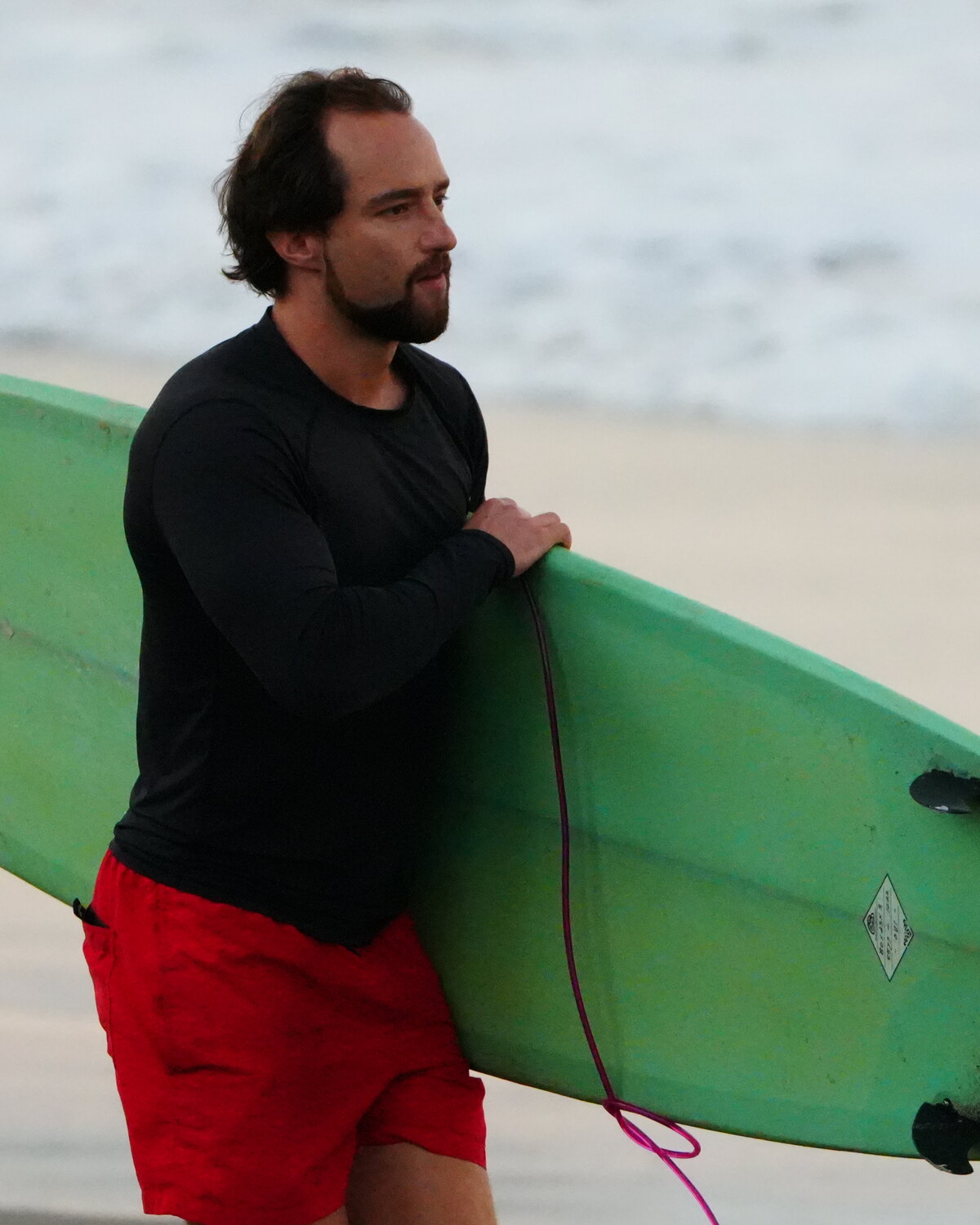 Tobias Salbaum walking the beach with a surfboard, Bali